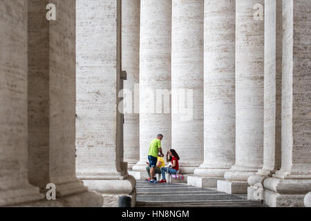 Rome, Italie- touristes reposant sur l'extérieur des piliers (nouveau) la Basilique St Pierre situé dans la Cité du Vatican (une enclave de Rome). Commencé par le pape Jules Banque D'Images