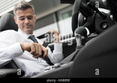 Businessman dans sa voiture de fixation de la ceinture de sécurité au volant concept Banque D'Images