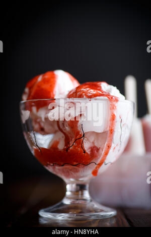 La crème glacée aux fruits en boîtes sur un fond noir Banque D'Images