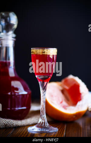 Pamplemousse doux cordial alcoolique dans la carafe avec un verre sur un tableau sombre Banque D'Images