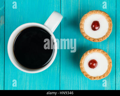 Tartelettes bakewell avec une tasse de café noir fort Banque D'Images