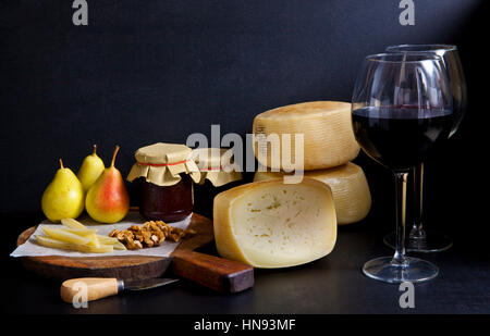 Deux verres de vin rouge et fromage pecorino, poires confiture. Fromage Parmesan. Apéritif italien. encore la vie. Banque D'Images