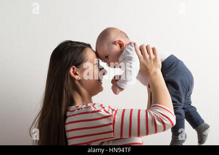 Belle mère tenant dans ses bras son bébé. Studio shot. Banque D'Images