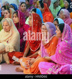 Les femmes assises sur le terrain à un mariage sikh en Malaisie portant des vêtements traditionnels très colorés. Banque D'Images