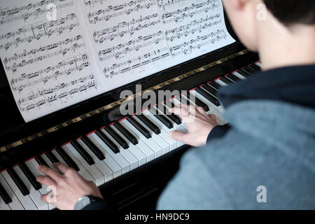 Teenage boy joue du piano Banque D'Images