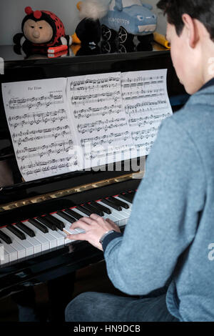 Teenage boy joue du piano Banque D'Images