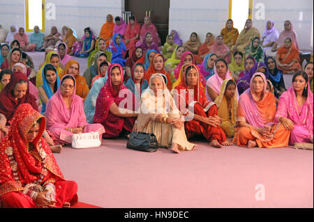 Les femmes assises sur le terrain à un mariage sikh en Malaisie portant des vêtements traditionnels très colorés. Banque D'Images