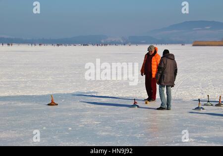 Les hommes jouer au curling sur le lac gelé de Seekirchen Wallersee. Salzburger Land, l'Autriche, l'Europe. Banque D'Images