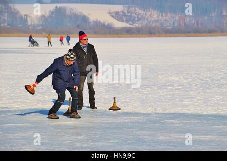 Les hommes jouer au curling sur le lac gelé de Seekirchen Wallersee. Salzburger Land, l'Autriche, l'Europe. Banque D'Images