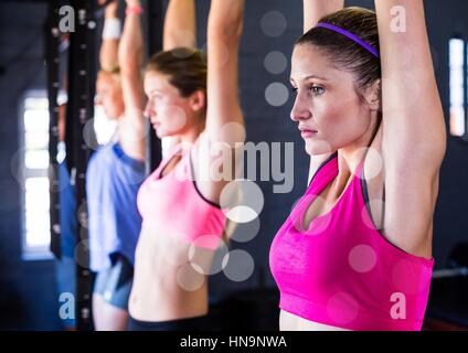 Digital composite de la condition physique des femmes faisant tirer avec ups bokeh in a gym Banque D'Images