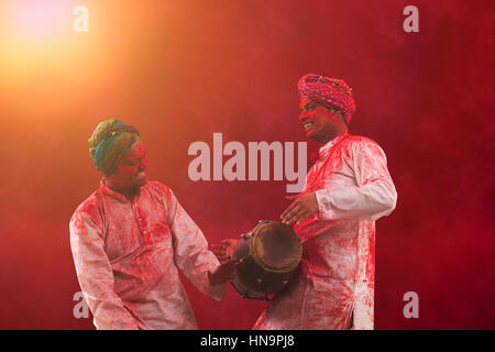 Deux jeunes hommes de couleur avec les Indiens au cours de danse du festival des couleurs Holi Banque D'Images