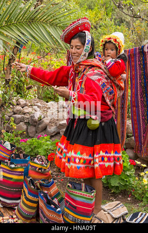 Mère indigènes en costume traditionnel, la filature, le tout-petit, Maras, Cusco, Pérou Province Banque D'Images