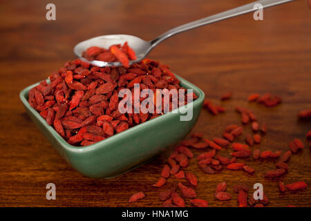 Les baies de goji dans un bol sur la table en bois Banque D'Images