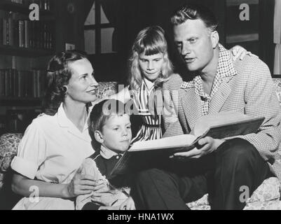 Évangéliste Billy Graham de lecture à partir d'une Bible de famille avec son épouse Ruth et leurs enfants dans le Graham's Montreat, Caroline du Nord accueil en 1957. Banque D'Images