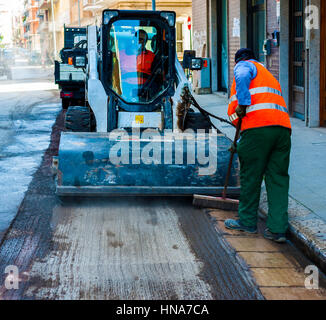 Sweeper mini pelle pièces jointes. La balayeuse balaie, recueille et déverse la saleté et les débris. Banque D'Images