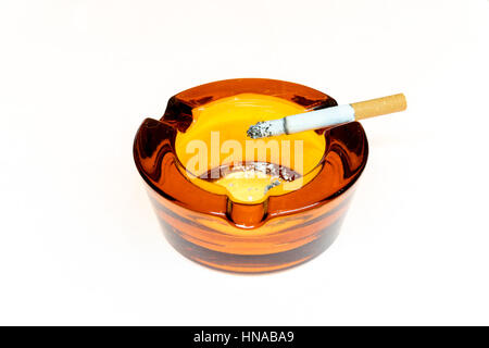 Cigarette dans un cendrier en verre isolated on white Banque D'Images