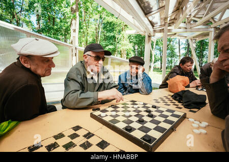 Biélorussie, MINSK - 9 mai 2014 : les retraités actifs, de vieux amis et de temps libre, les hommes âgés s'amuser et jouer aux échecs au city park. Banque D'Images