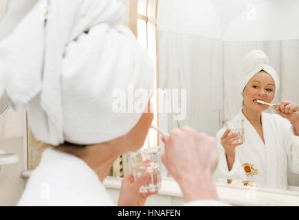 Junge Frau im Badezimmer putzt sich die Zaehne - jeune femme dans la baignoire se brosser les dents Banque D'Images