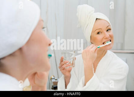 Junge Frau im Badezimmer putzt sich die Zaehne - jeune femme dans la baignoire se brosser les dents Banque D'Images