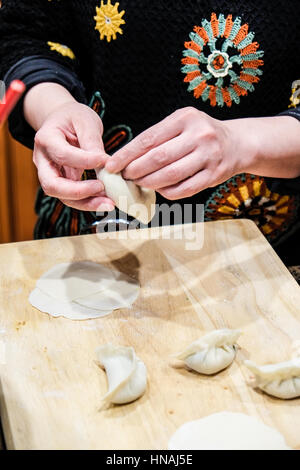 Les personnes faisant des raviolis chinois Banque D'Images