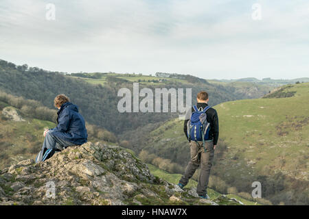 Deux randonneurs prennent dans la vue au sommet du nuage, Thorpe, Derbyshire Peak District. Banque D'Images