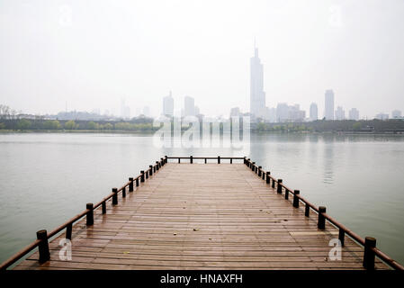 Sur la jetée au bord du lac Lac Xuanwu avec des bâtiments de la ville dans le brouillard Banque D'Images