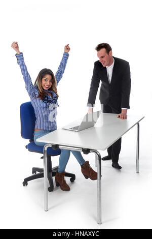 Secrétaire avec laptop et patron semblent heureux avec le résultat dans studio contre fond blanc et elle est cheering Banque D'Images