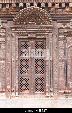 Travail-lattic richement sculptée porte de bois d'une maison ancienne, avec un linteau en bois sculptés de divinités hindoues à Bhaktapur, Katmandou Banque D'Images