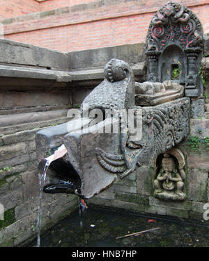 Diffuseur d'eau en bronze finement sculptés avec des motifs religieux et d'animaux que les canaux d'une source souterraine dans une place publique, Katmandou, Népal Banque D'Images