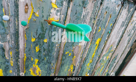 Dart flèche dans un mur étagère en bois vert Banque D'Images