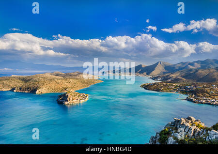 Vue panoramique sur le golfe d'Elounda avec le célèbre village d'Elounda et l'île de Spinalonga au coucher du soleil avec de beaux nuages et mer calme, Crète, Banque D'Images