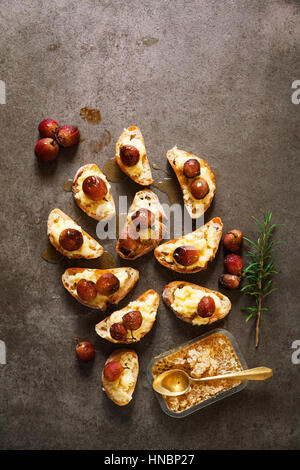 Camembert au four avec des canapés, des raisins et du miel sur une table en bois bruschette Banque D'Images