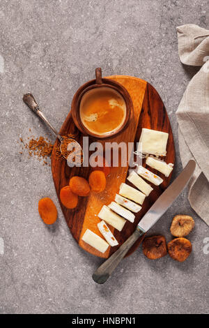 Tranches de Turrón sur une planche en bois avec des abricots secs, figues séchées et une tasse de café. collation santé, super aliment Banque D'Images