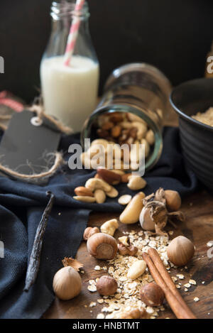 Les noix, d'avoine et des bâtons de cannelle avec du lait Banque D'Images