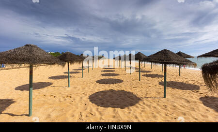 Des chaises longues et des parasols sur la plage, Algarve, Portugal Banque D'Images