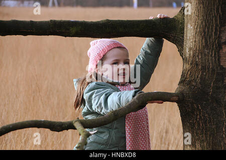 Girl climbing un arbre Banque D'Images