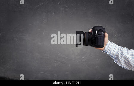 Proche de l'homme main dans shirt holding photocamera Banque D'Images