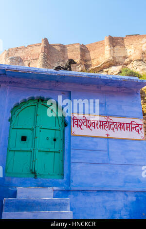 Un chien se trouve sur le toit du temple de Mahadeva Vishveshvara à Jodhpur, Inde, dans l'ombre de la Mehrangarh Fort. Banque D'Images