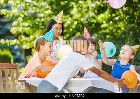 Les enfants s'amusent ensemble à une fête d'anniversaire pour enfants dans le jardin Banque D'Images