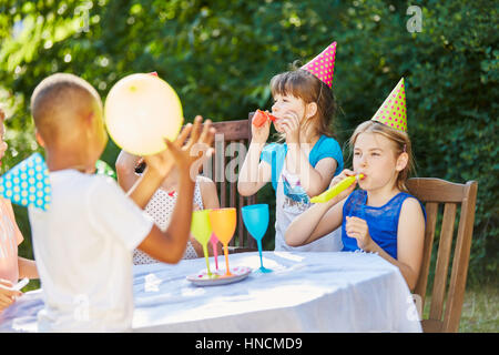 Anniversaire enfants célébrer ensemble dans un jardin et s'amuser Banque D'Images