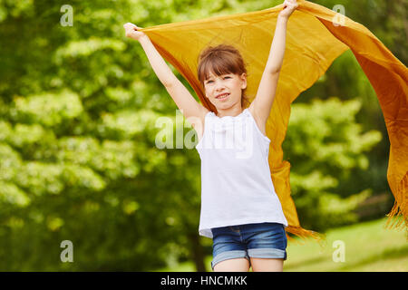 Girl est titulaire d'un chiffon en l'air tandis que le vent se déplace avec la liberté Banque D'Images