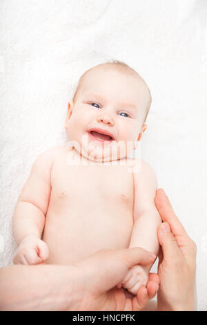 Trois mois baby girl reçoit massage des bras d'une femme massothérapeute Banque D'Images