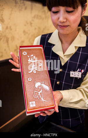 Girl montrant Castella génoise, est un gâteau populaire, dans Edomachi Bunmeido shop à 1-1, la vente de gâteau Castella depuis 1900, Nagasaki, Japon. Banque D'Images