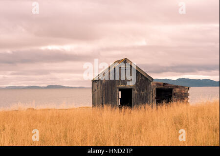 Chalet cottage en bois abandonnés dans la campagne avec vue sur la mer et les montagnes en arrière-plan. Effet Vintage Banque D'Images