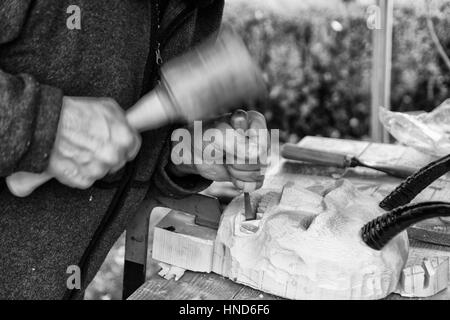 Carpenter sculpte un masque de carnaval en bois. Banque D'Images