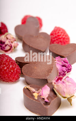 Coeurs de chocolat brut, roses et framboises Banque D'Images