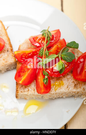 Bruschetta aux tomates italiennes avec le thym et les feuilles de menthe Banque D'Images