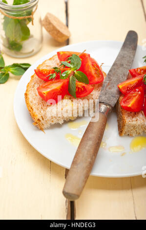 Bruschetta aux tomates italiennes avec le thym et les feuilles de menthe Banque D'Images