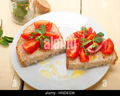 Bruschetta aux tomates italiennes avec le thym et les feuilles de menthe Banque D'Images