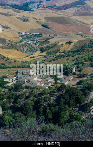 Paysages du centre de la Sicile en été. Avec les collines typiques de la Sicile et d'oliviers, avec une route qui serpente à travers les montagnes. Banque D'Images